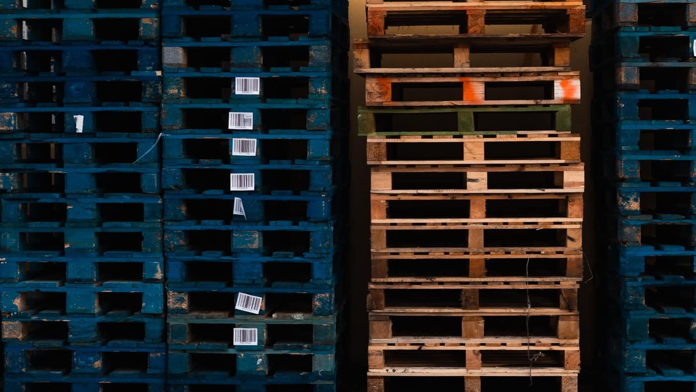 Wooden pallets stacked and labelled in a warehouse